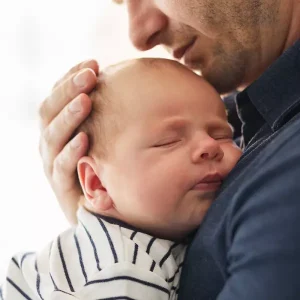 Um pai segurando o filho bebê no colo
