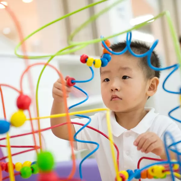 Criança interagindo com brinquedos educativos e sensoriais