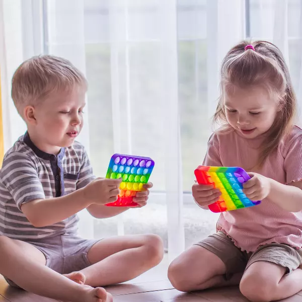 Crianças trabalhando a estimulação sensorial com brinquedos sensoriais pop it e fidget toys